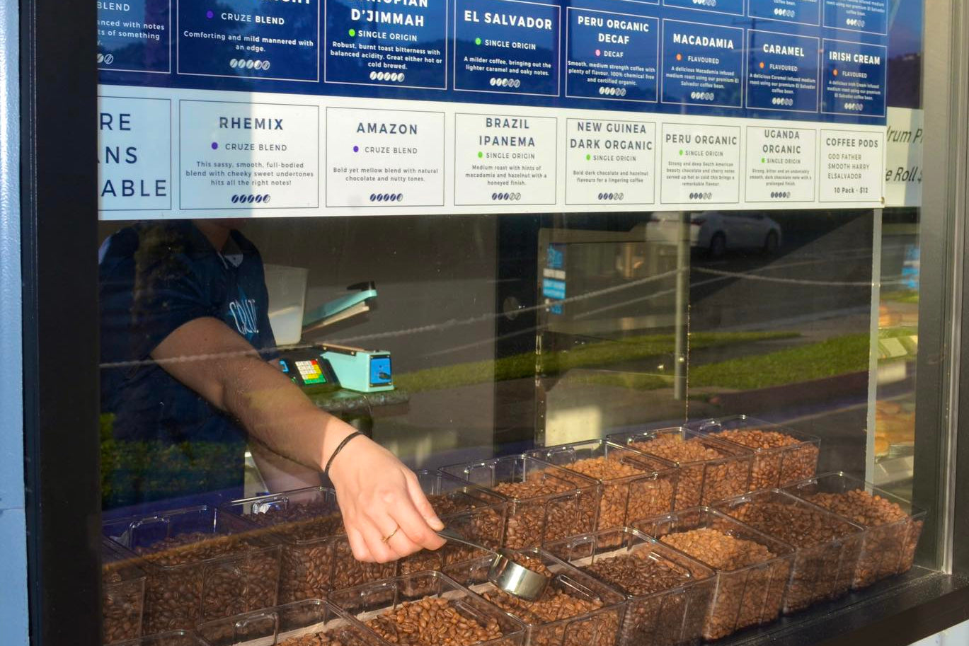 Display case with coffee beans and product labels in a store.